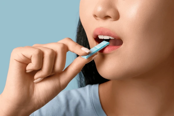 Woman using InvisiRelief chewing gum for discreet throat relief